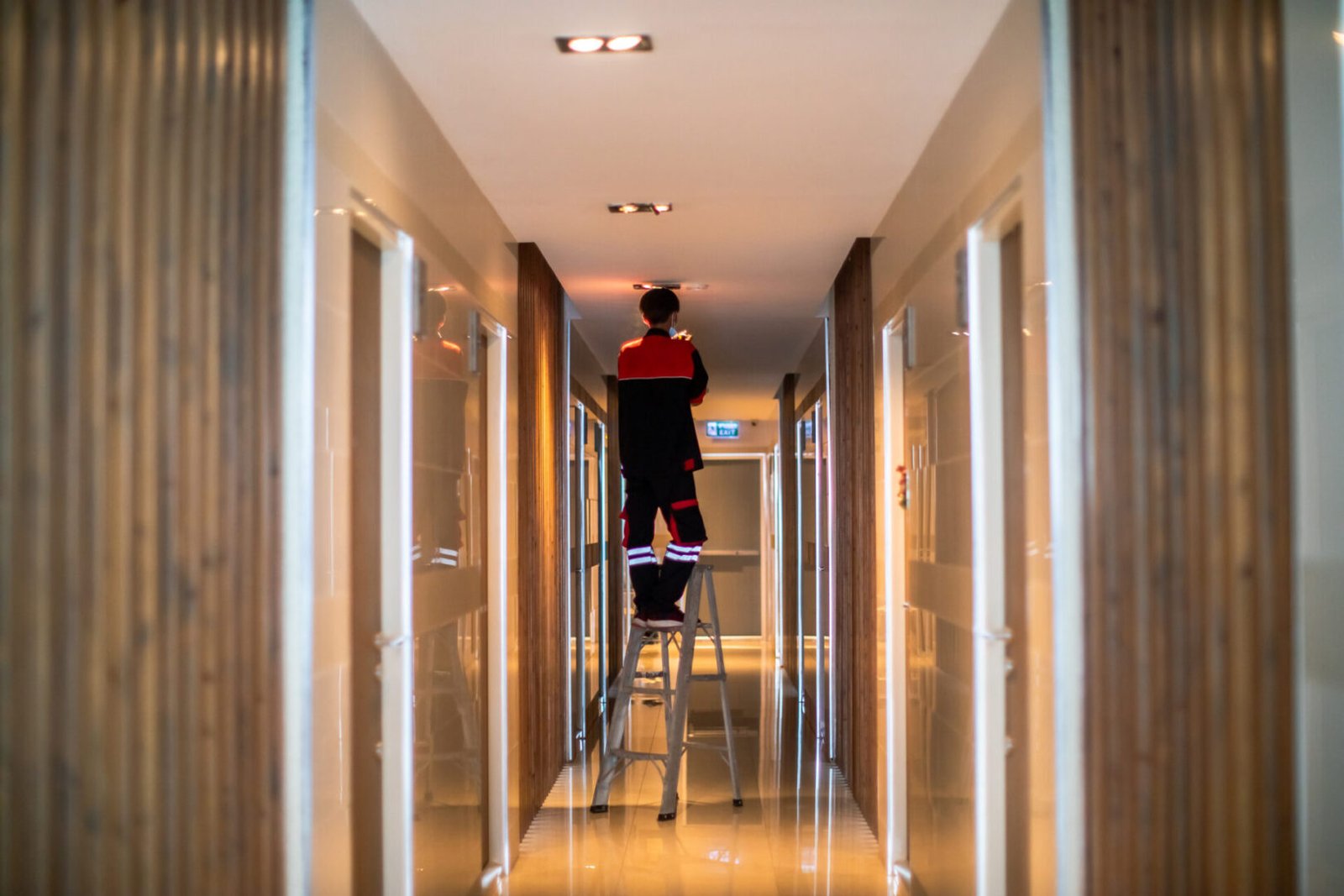 Technician repairing lights in corridor